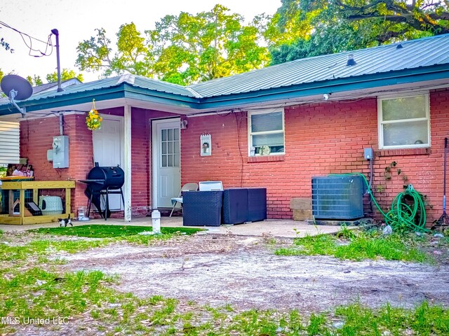 2220 18th Ave, Gulfport, MS 39501 - rear view of property featuring brick siding, central AC unit, a patio, and metal roof