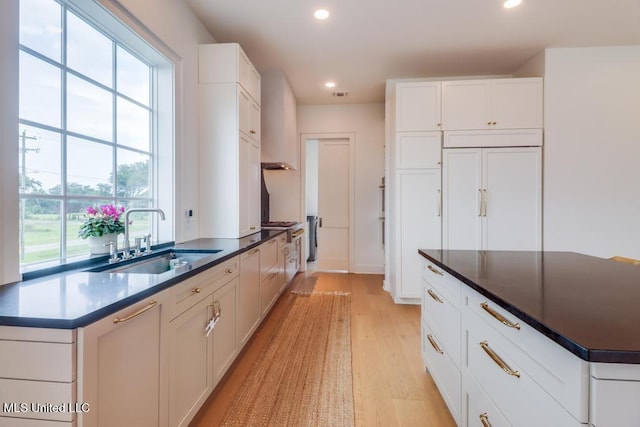405 Mason Ave, Long Beach, MS 39560 - kitchen featuring recessed lighting, light wood finished floors, white cabinets, dark countertops, and a kitchen island