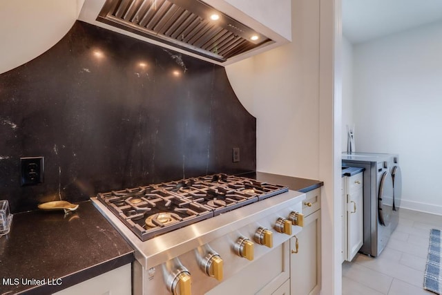 405 Mason Ave, Long Beach, MS 39560 - kitchen with custom exhaust hood, stainless steel gas stovetop, white cabinets, and light tile patterned flooring
