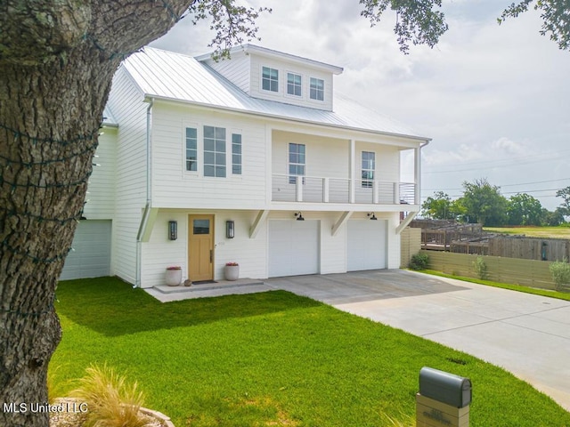 405 Mason Ave, Long Beach, MS 39560 - view of front of property featuring concrete driveway, a garage, a balcony, a metal roof, and a front lawn