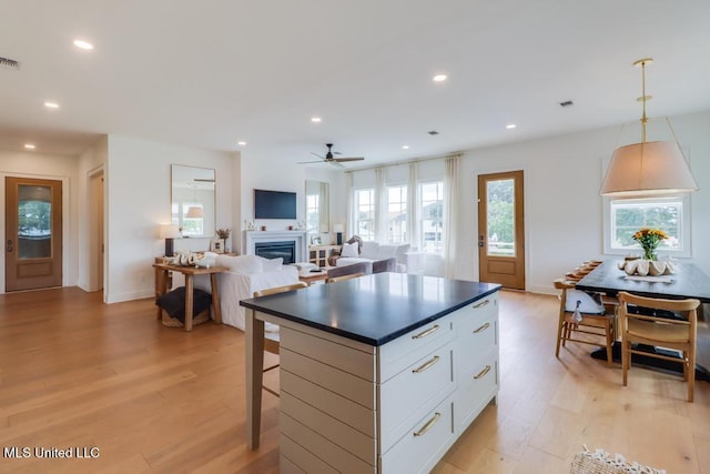 405 Mason Ave, Long Beach, MS 39560 - kitchen with light wood finished floors, dark countertops, ceiling fan, white cabinets, and recessed lighting