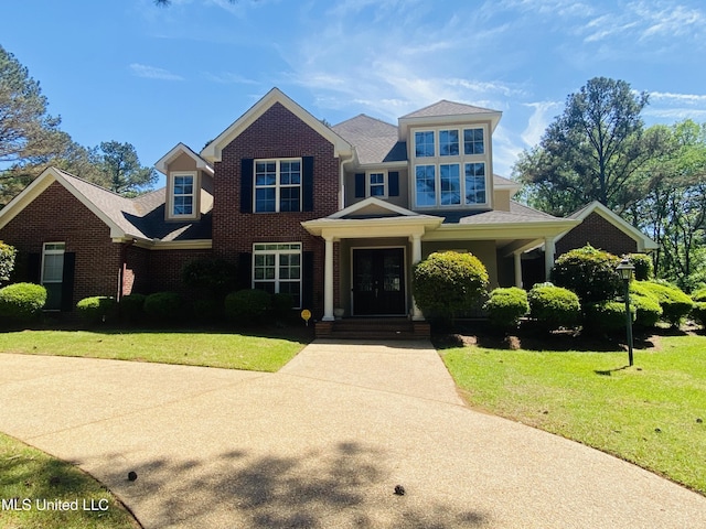 view of front of property with brick siding and a front lawn