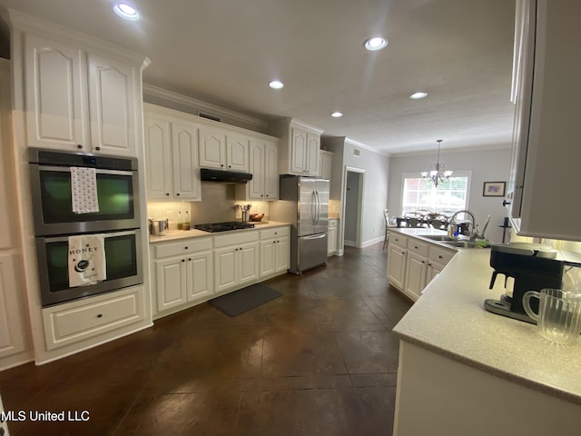 kitchen featuring ornamental molding, appliances with stainless steel finishes, under cabinet range hood, a sink, and light countertops