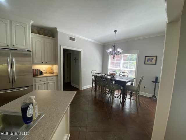 dining space with dark tile patterned flooring, ornamental molding, visible vents, baseboards, and a notable chandelier