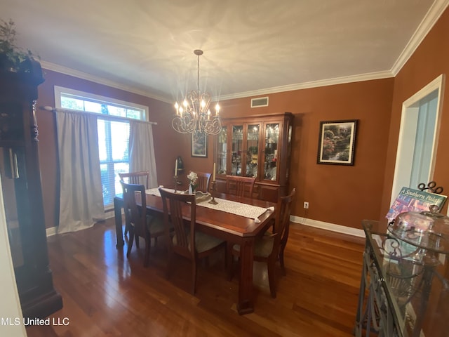 dining space featuring wood finished floors, an inviting chandelier, ornamental molding, and visible vents