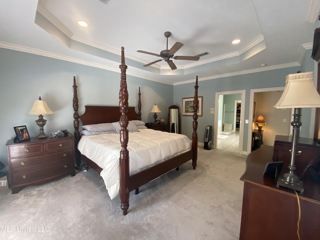 bedroom with visible vents, baseboards, crown molding, a tray ceiling, and light colored carpet