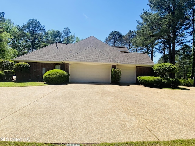 view of front facade with brick siding, roof with shingles, a garage, and concrete driveway