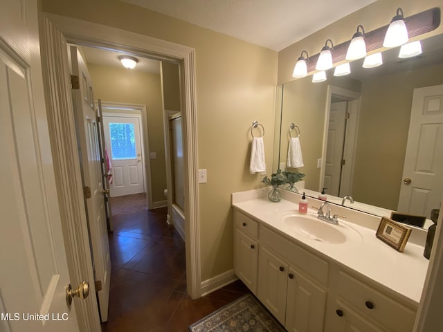 full bathroom with a shower with door, tile patterned floors, vanity, and baseboards
