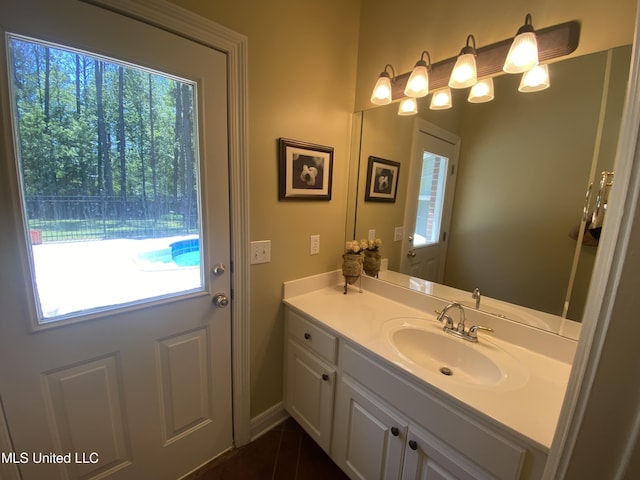 bathroom featuring tile patterned flooring, baseboards, and vanity