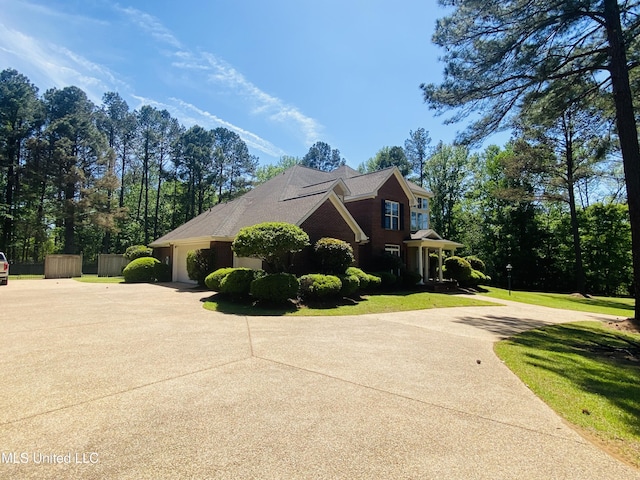 view of property exterior featuring a garage, driveway, and a lawn