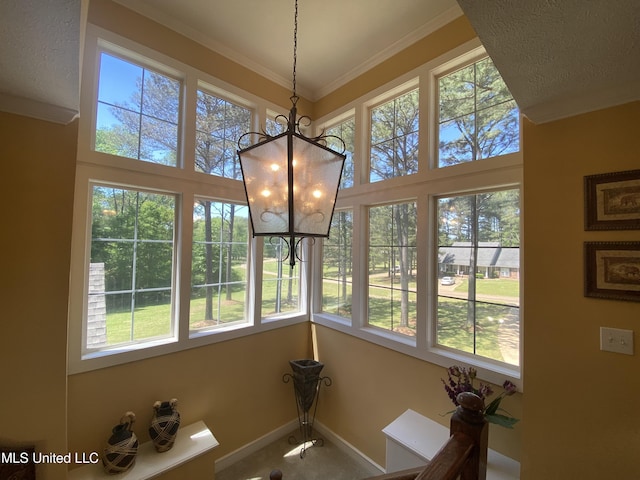 interior space featuring a towering ceiling, a notable chandelier, baseboards, and a healthy amount of sunlight