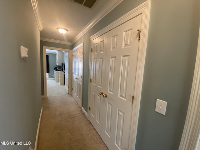 hallway featuring ornamental molding, visible vents, baseboards, and light colored carpet