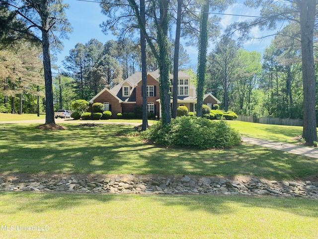 view of front of home featuring fence and a front lawn