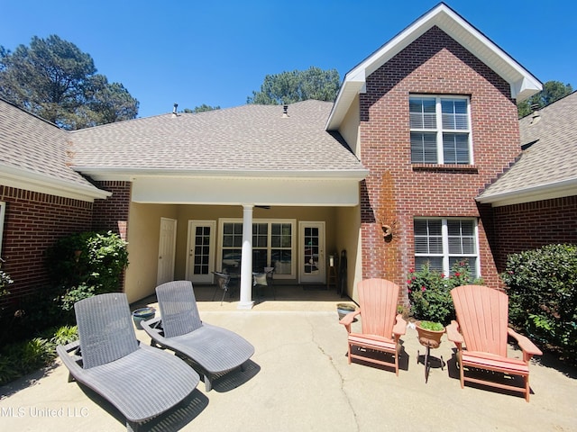 back of property with a patio, a shingled roof, and brick siding