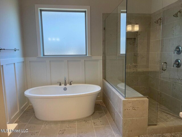 7228 Edgewater Dr, Olive Branch, MS 38654 - bathroom featuring a decorative wall, a shower stall, a freestanding bath, and a wainscoted wall