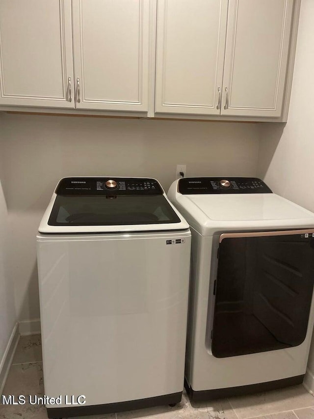7228 Edgewater Dr, Olive Branch, MS 38654 - laundry area featuring separate washer and dryer, baseboards, and cabinet space
