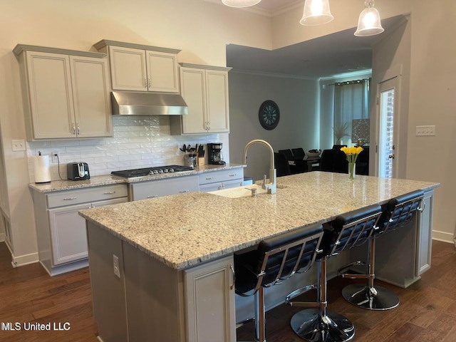 7228 Edgewater Dr, Olive Branch, MS 38654 - kitchen with under cabinet range hood, stainless steel gas stovetop, a sink, ornamental molding, and tasteful backsplash