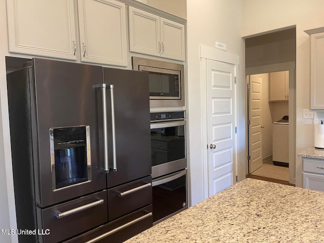7228 Edgewater Dr, Olive Branch, MS 38654 - kitchen with appliances with stainless steel finishes, light stone countertops, and washer / clothes dryer