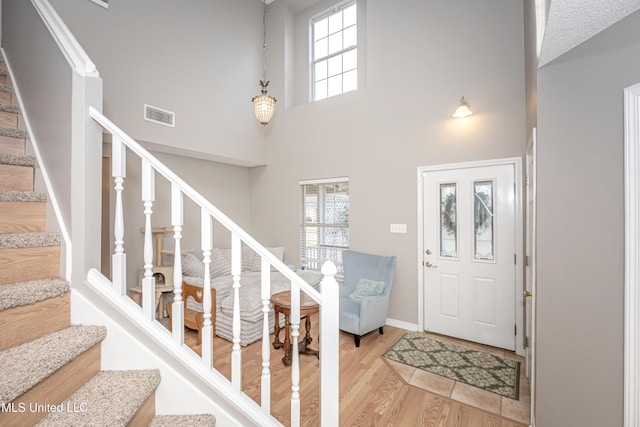 entrance foyer with hardwood / wood-style floors and a high ceiling