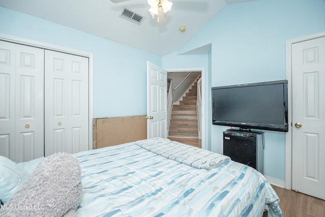 bedroom with ceiling fan, hardwood / wood-style floors, and lofted ceiling