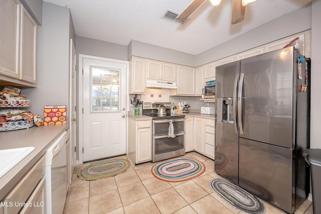 kitchen featuring ceiling fan, light tile patterned flooring, stainless steel appliances, and a textured ceiling