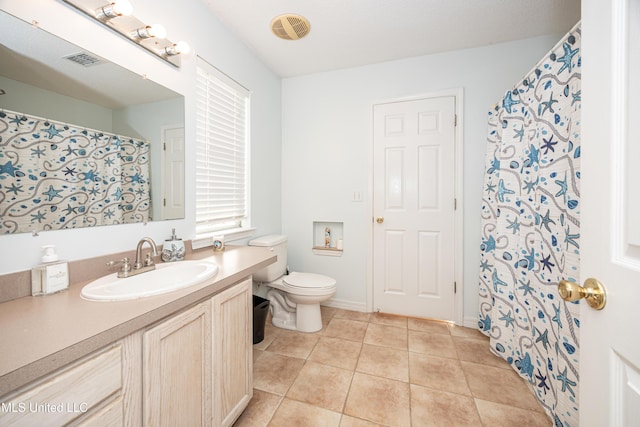 bathroom with tile patterned flooring, vanity, and toilet