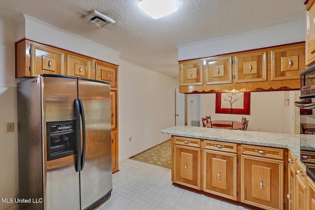 182 Brandon Williamsburg Rd, Mendenhall, MS 39114 - kitchen featuring stainless steel fridge with ice dispenser, a peninsula, brown cabinets, light countertops, and a textured ceiling