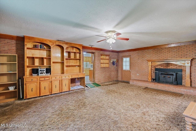 182 Brandon Williamsburg Rd, Mendenhall, MS 39114 - unfurnished living room with carpet, ceiling fan, a textured ceiling, brick wall, and a wood stove