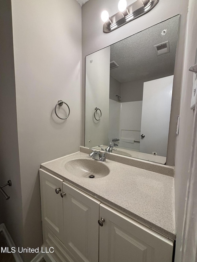 6405 Collinwood Rd, Horn Lake, MS 38637 - bathroom with vanity, a textured ceiling, walk in shower, and visible vents