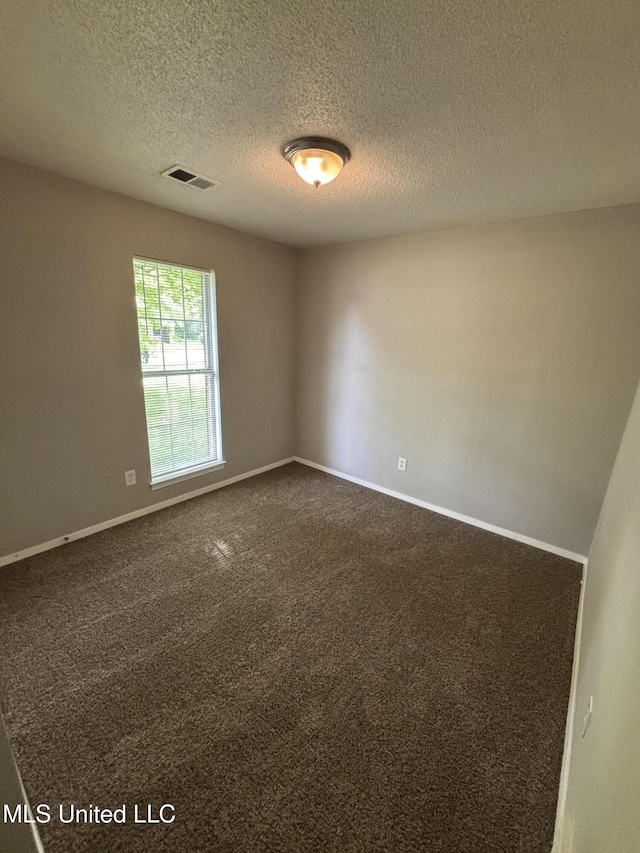 6405 Collinwood Rd, Horn Lake, MS 38637 - spare room with baseboards, a textured ceiling, visible vents, and dark carpet