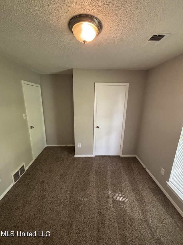6405 Collinwood Rd, Horn Lake, MS 38637 - empty room with baseboards, dark colored carpet, a textured ceiling, and visible vents