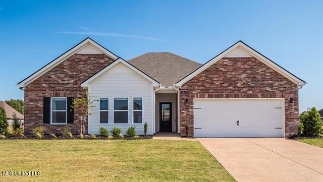 view of front of property featuring a front lawn and a garage