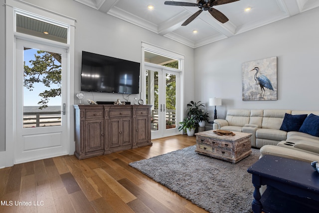 living room with a healthy amount of sunlight, beamed ceiling, and hardwood / wood-style floors