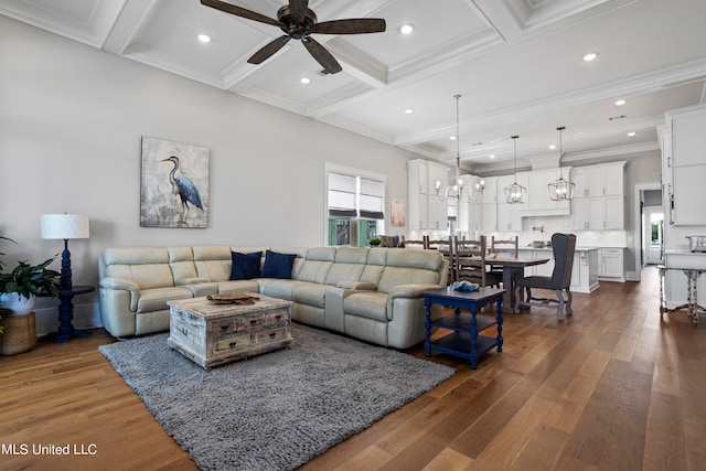 living room with ceiling fan with notable chandelier, dark hardwood / wood-style flooring, coffered ceiling, beam ceiling, and ornamental molding