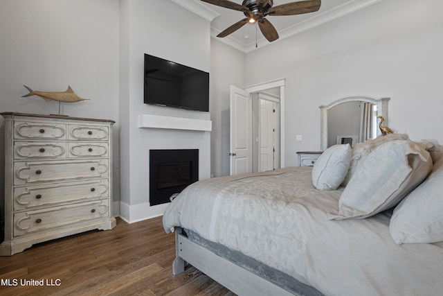 bedroom with crown molding, ceiling fan, and dark hardwood / wood-style flooring