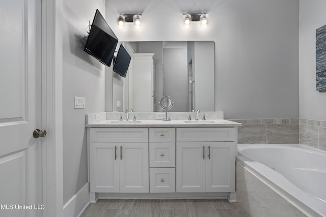 bathroom featuring vanity and tiled bath