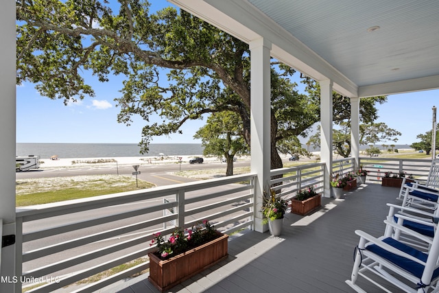 deck featuring a view of the beach and a water view