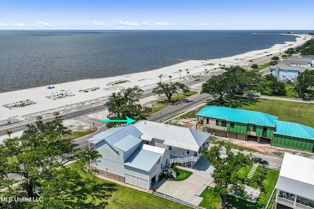 birds eye view of property with a water view and a beach view