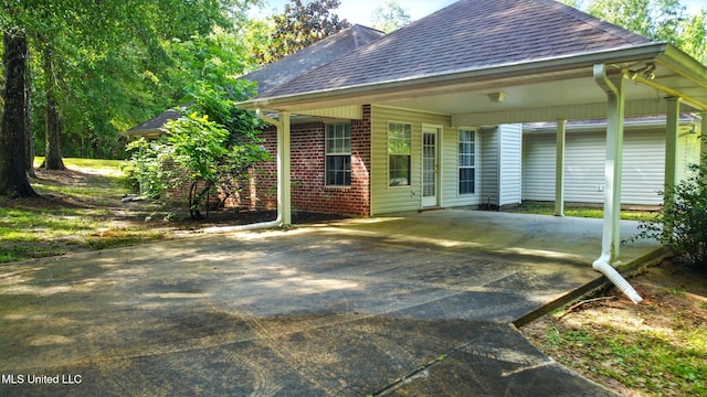 129 E Sunnybrook Rd, Carriere, MS 39426 - back of house with brick siding, concrete driveway, a shingled roof, and a carport
