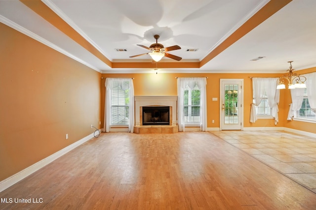 129 E Sunnybrook Rd, Carriere, MS 39426 - unfurnished living room featuring a raised ceiling, ornamental molding, a ceiling fan, a fireplace with raised hearth, and a chandelier