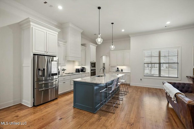 kitchen featuring appliances with stainless steel finishes, white cabinetry, crown molding, and a kitchen bar