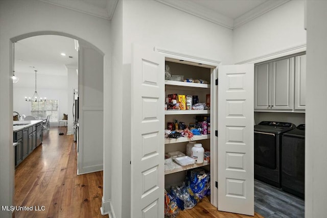 storage area with washer and clothes dryer and a sink