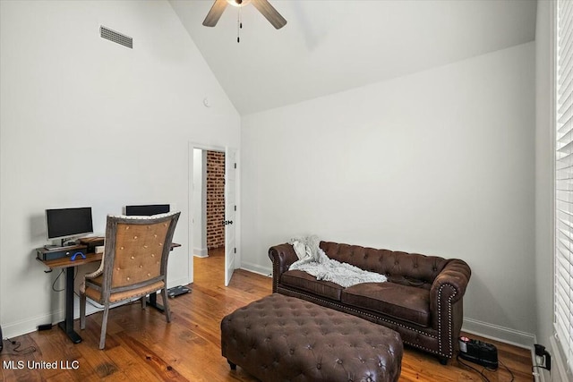 office featuring high vaulted ceiling, wood finished floors, visible vents, and baseboards