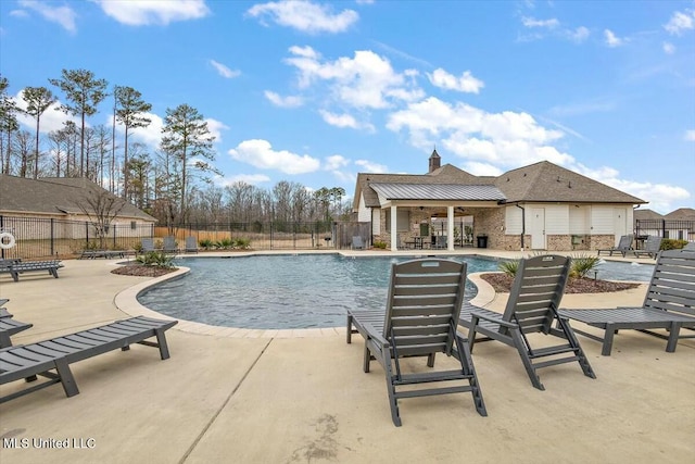 pool with a patio and fence