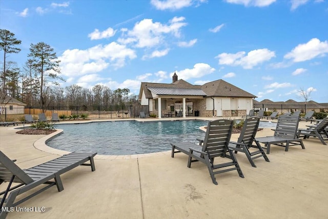 community pool featuring an outbuilding, a patio, and fence