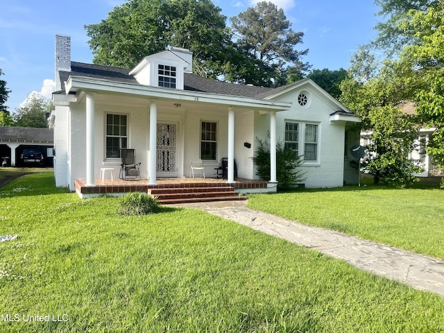 58 Snider St, Grenada, MS 38901 - view of front of house featuring a porch, brick siding, a front lawn, and a chimney
