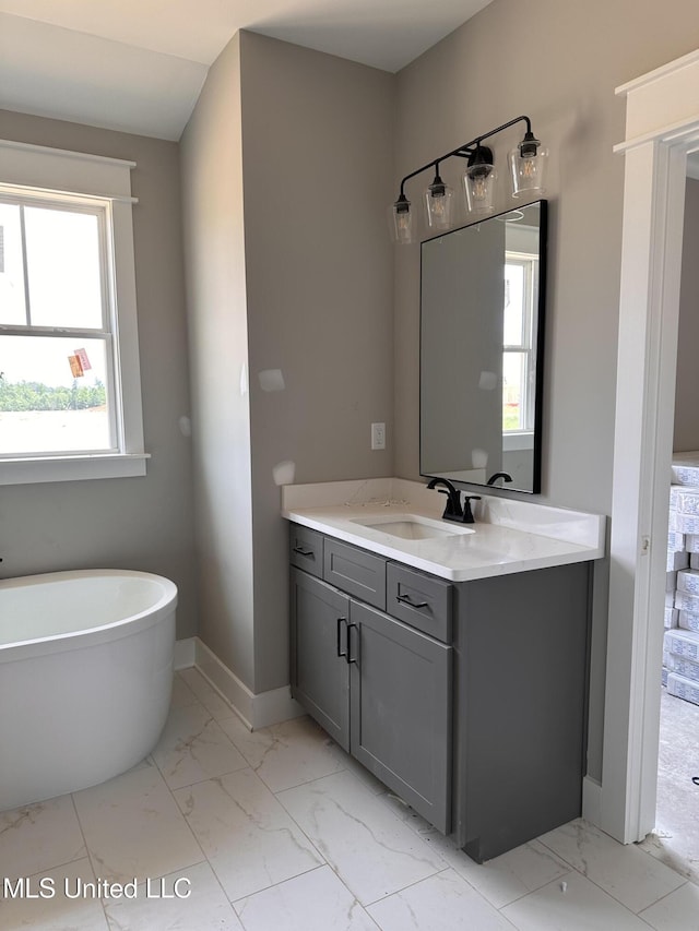 1740 Bakersfield Way, Nesbit, MS 38651 - full bathroom with vanity, marble finish flooring, a soaking tub, and baseboards