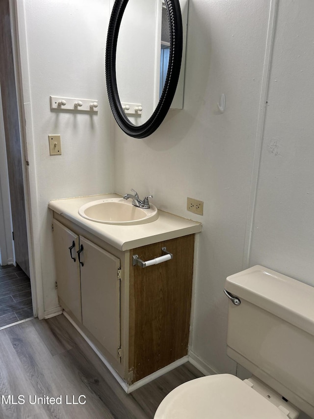 97131 Kapalama Dr, Diamondhead, MS 39525 - half bathroom with toilet, vanity, wood finished floors, and baseboards
