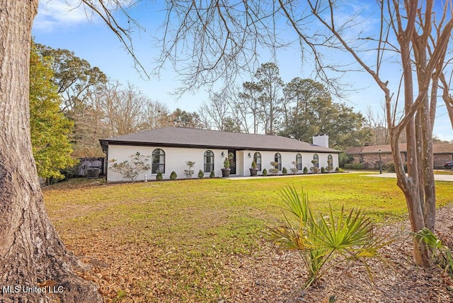 ranch-style house featuring a chimney and a front yard