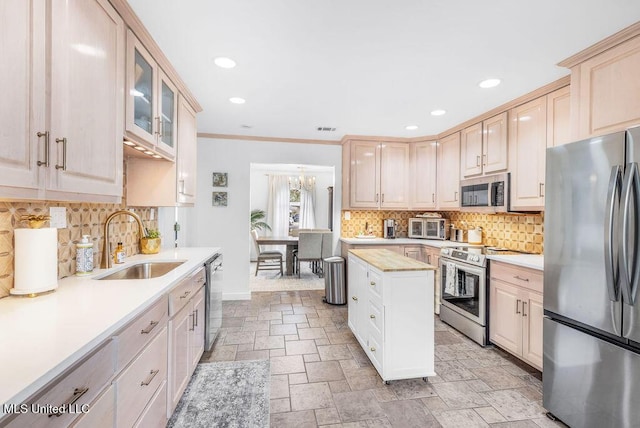 kitchen with sink, stainless steel appliances, ornamental molding, light brown cabinetry, and decorative backsplash